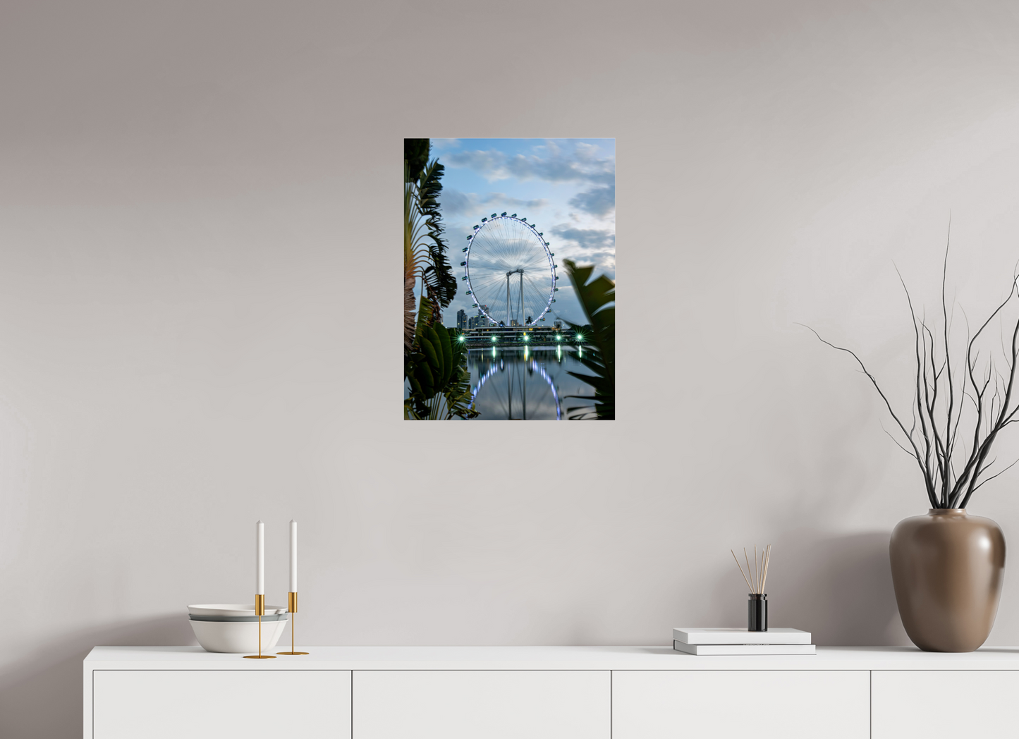 Ferris wheel artwork on a wall above a white cabinet with decorative items.