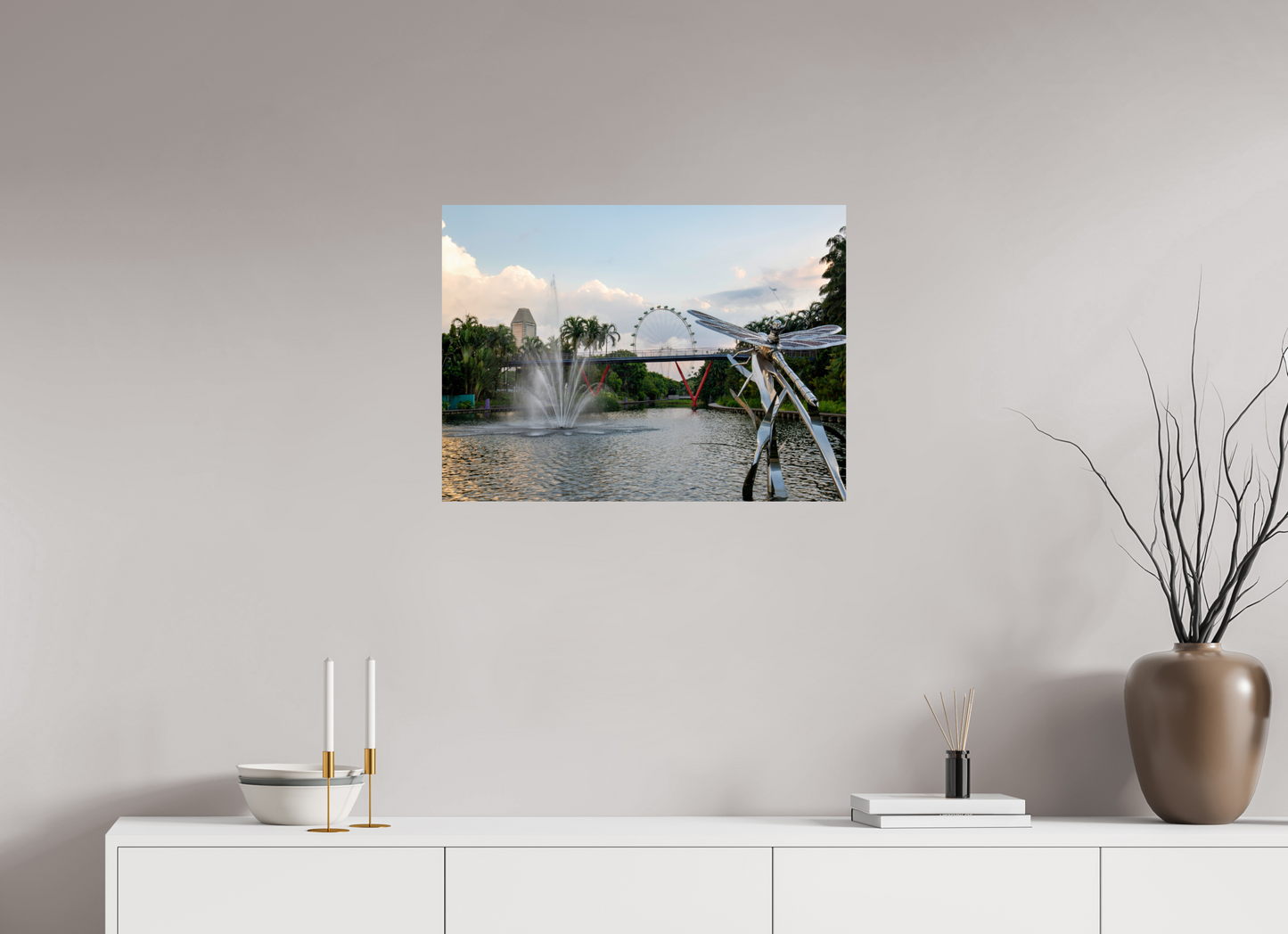 Framed photograph of a scenic view with a Ferris wheel on a wall above a white cabinet.
